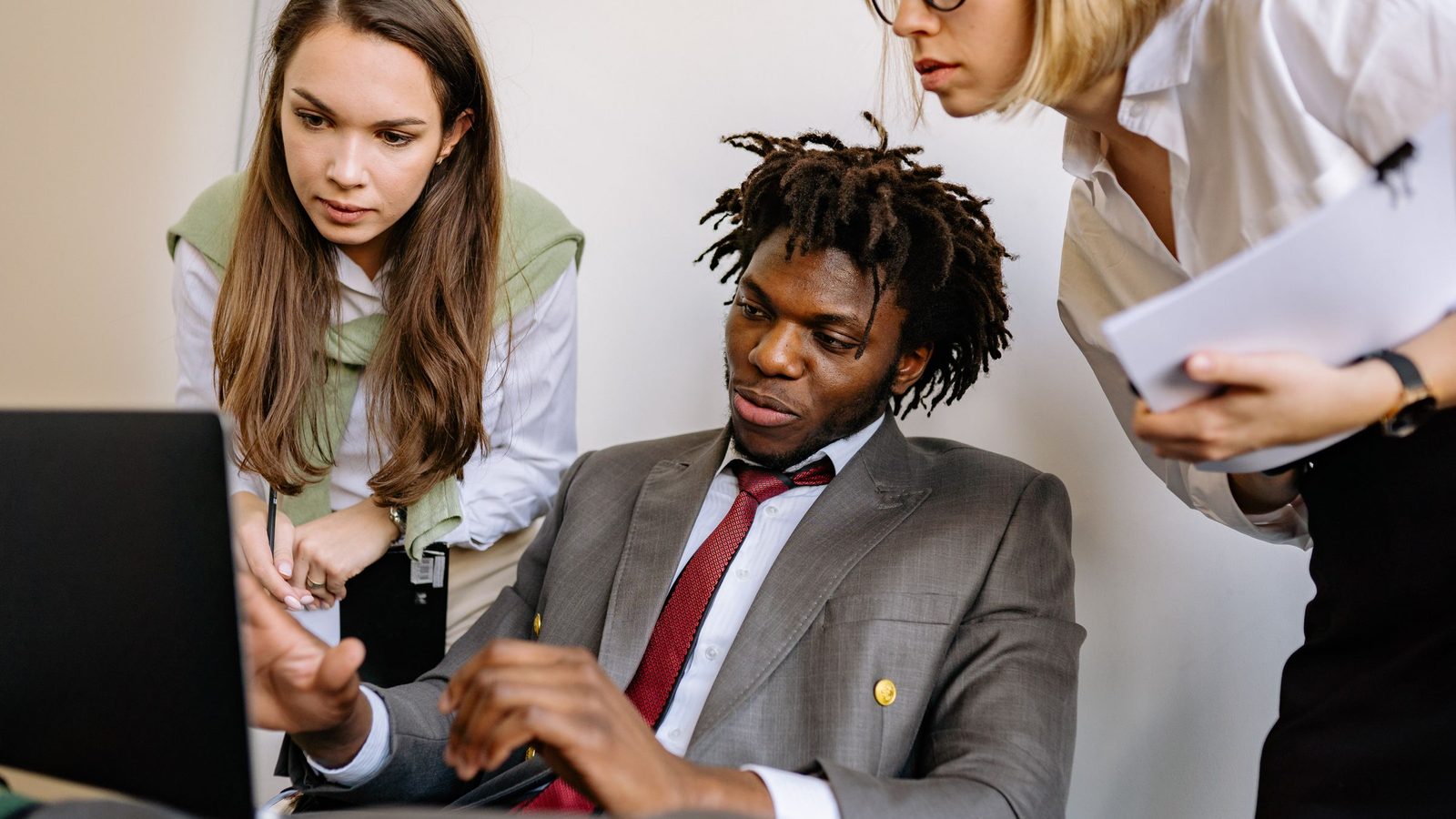 Three diverse colleagues engaged in a collaborative brainstorming session in an office