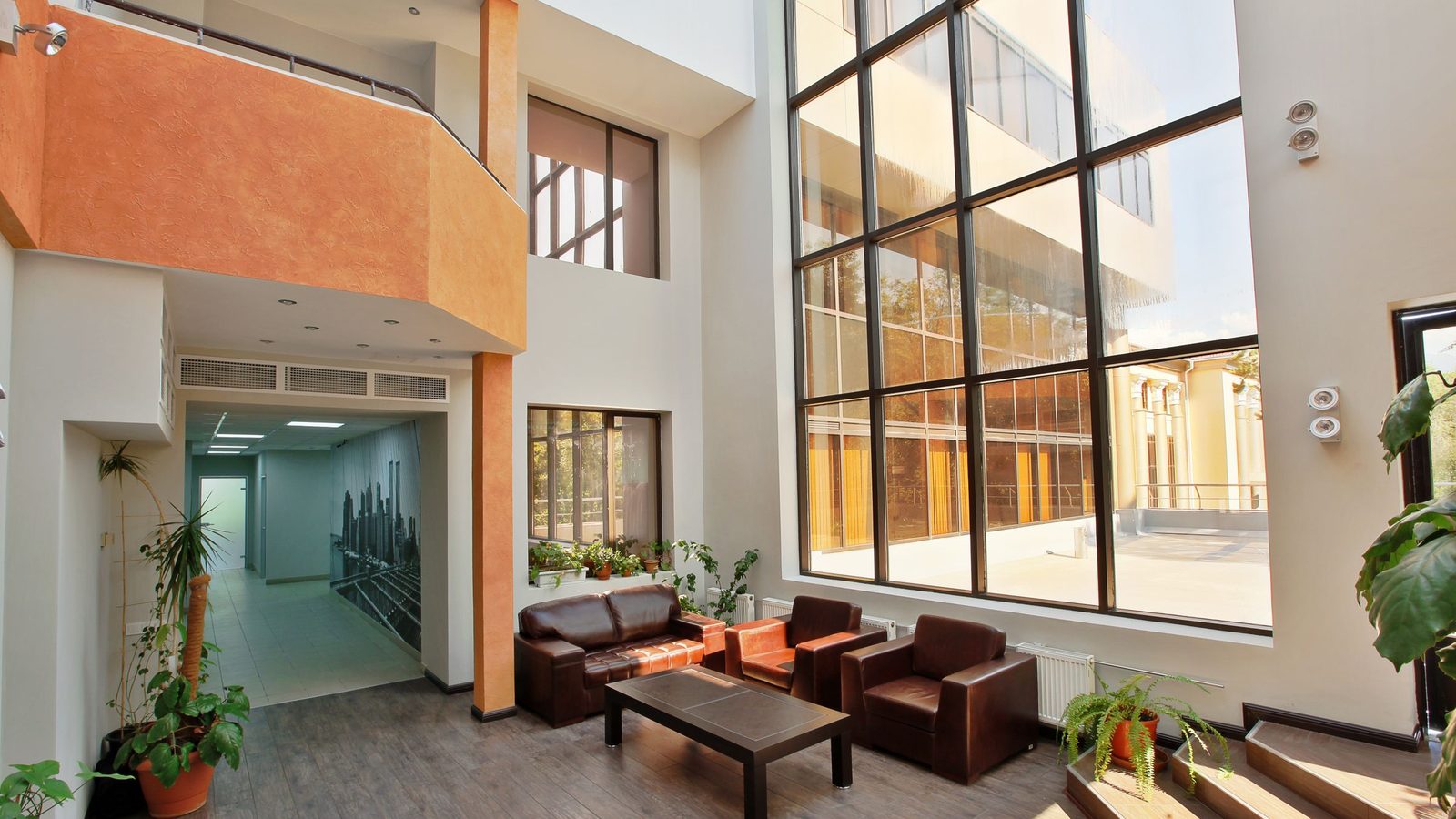 Modern commercial office lobby with reception staff and a cleaning operative maintaining the space