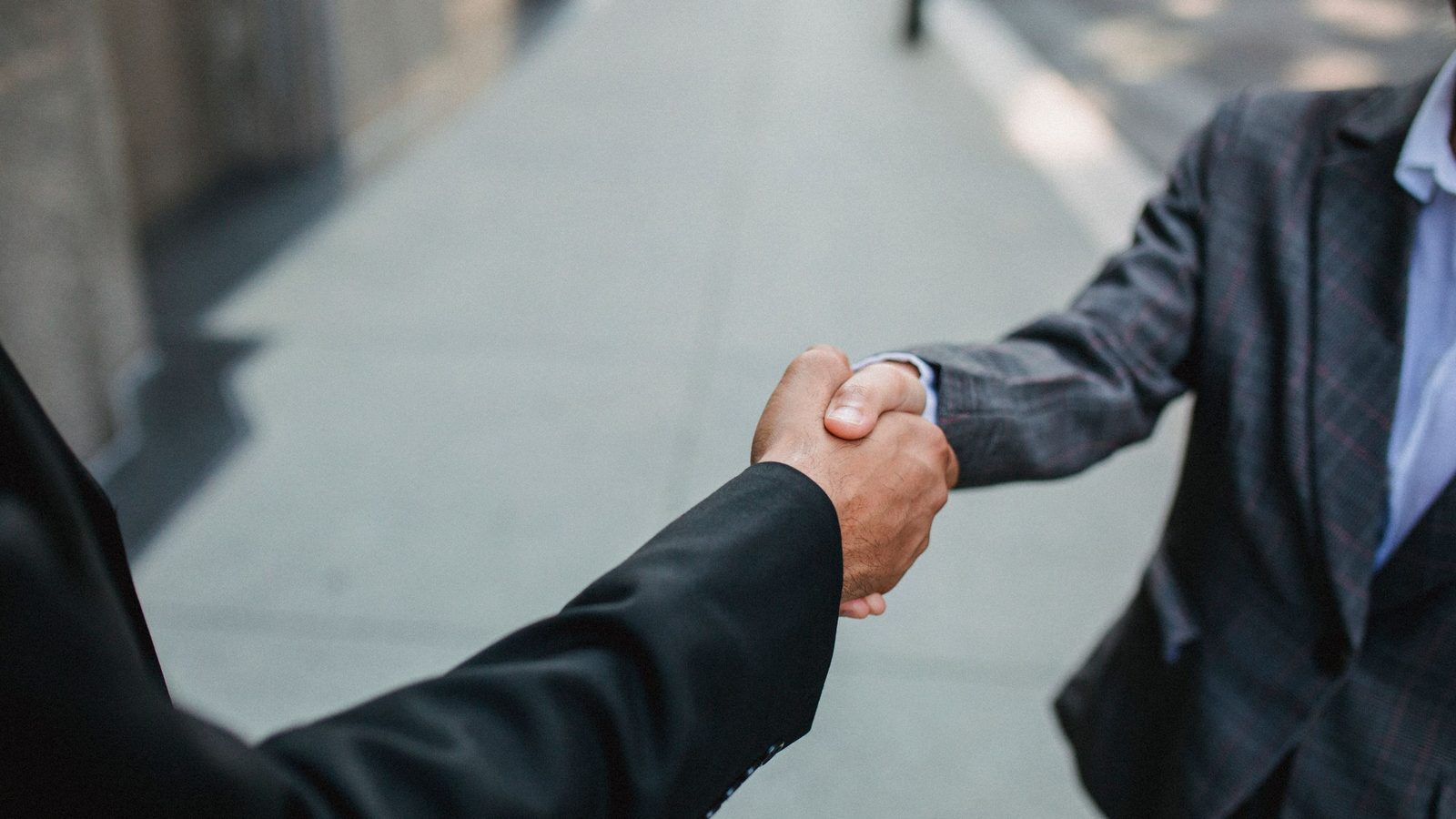 Close-up of two business people shaking hands outdoors