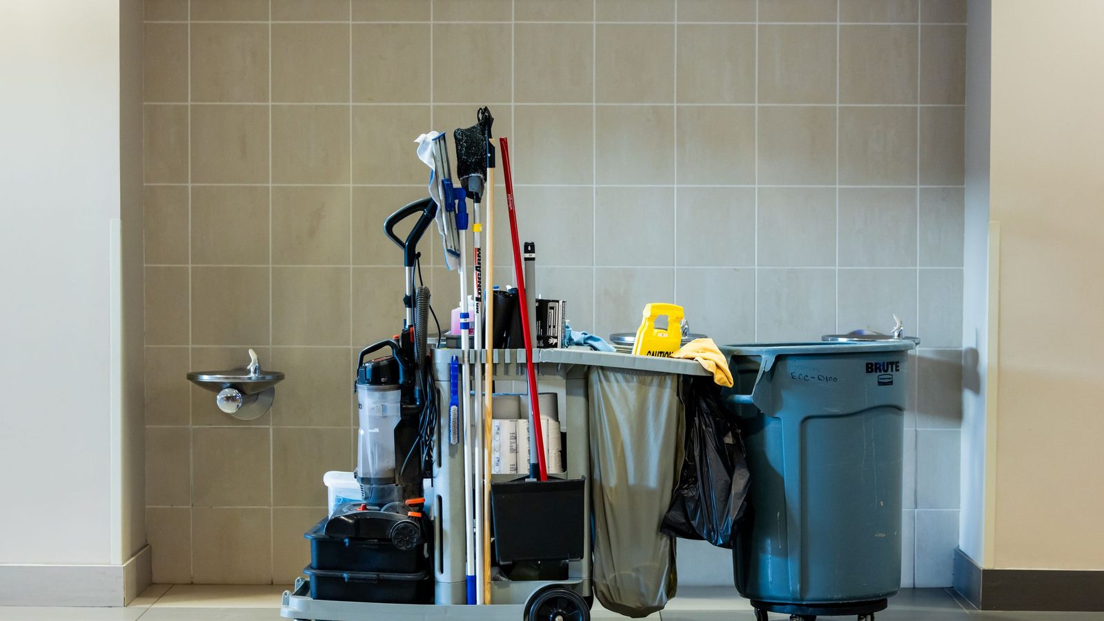 A comprehensive collection of professional cleaning tools on a cart in an indoor environment