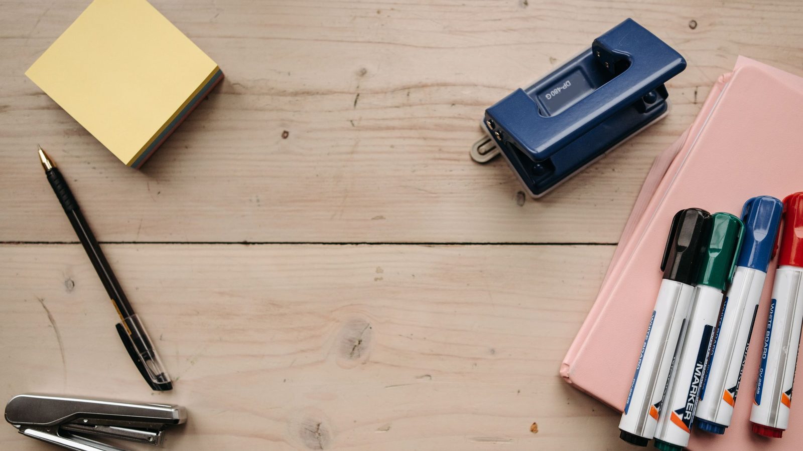 Flat lay of office supplies on a wooden desk for a neat workspace setup
