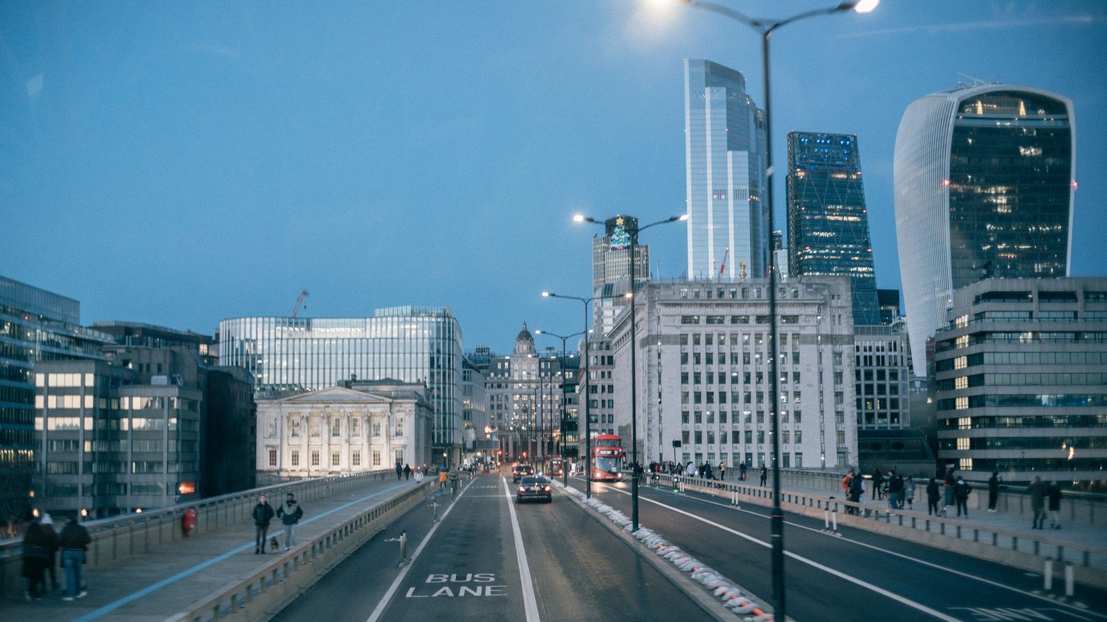 Busy evening cityscape of London Bridge with illuminated skyscrapers and traffic