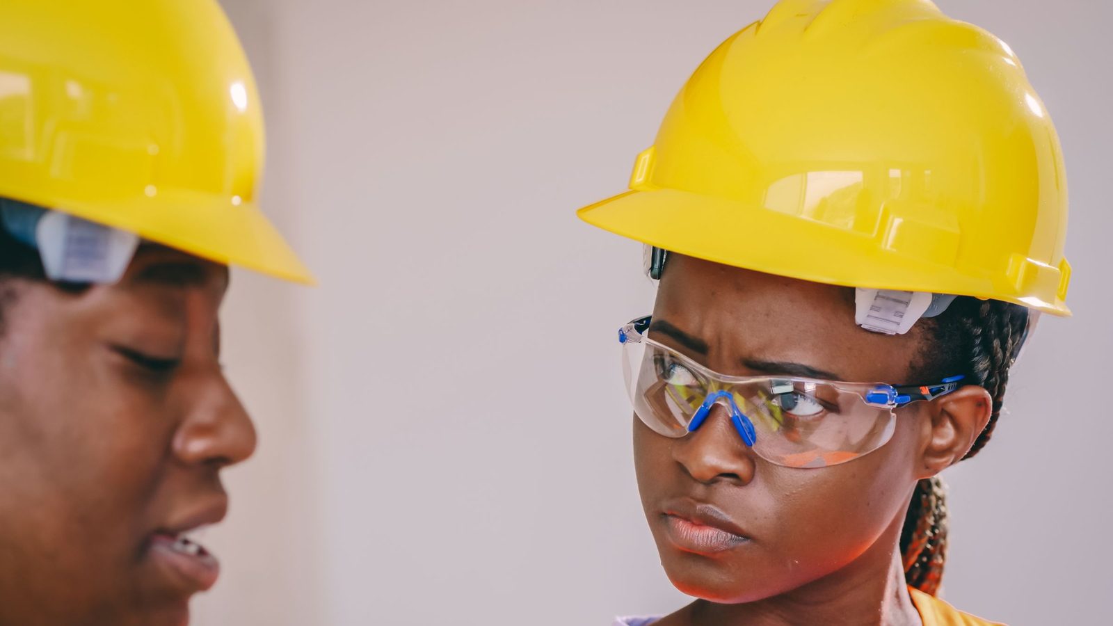 Close-up of African American construction workers wearing safety gear, including helmets and vests