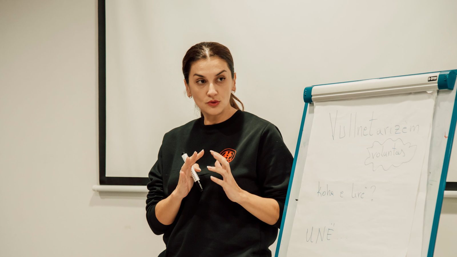 Woman confidently presenting with a flip chart in a classroom setting